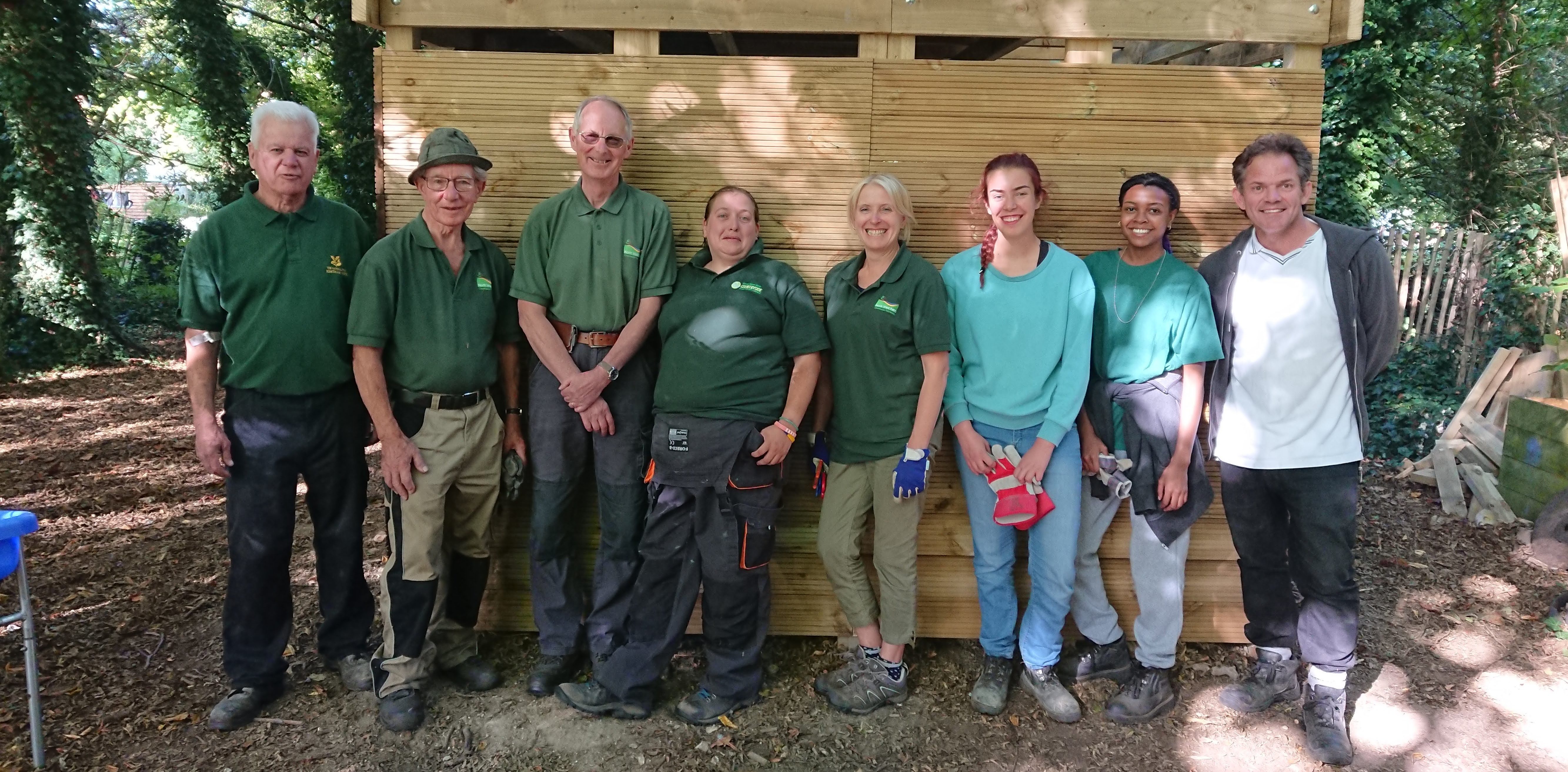 Group photo of volunteers standing in front of outdoor classroom they built at Shoreham Primary School